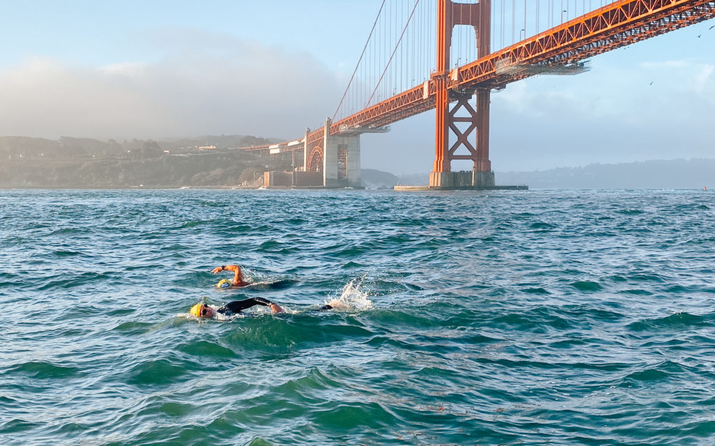 Two swimmers beginning the 10-km Bridge to Bridge swim at the Golden Gate Bridge in San Francisco Bay.